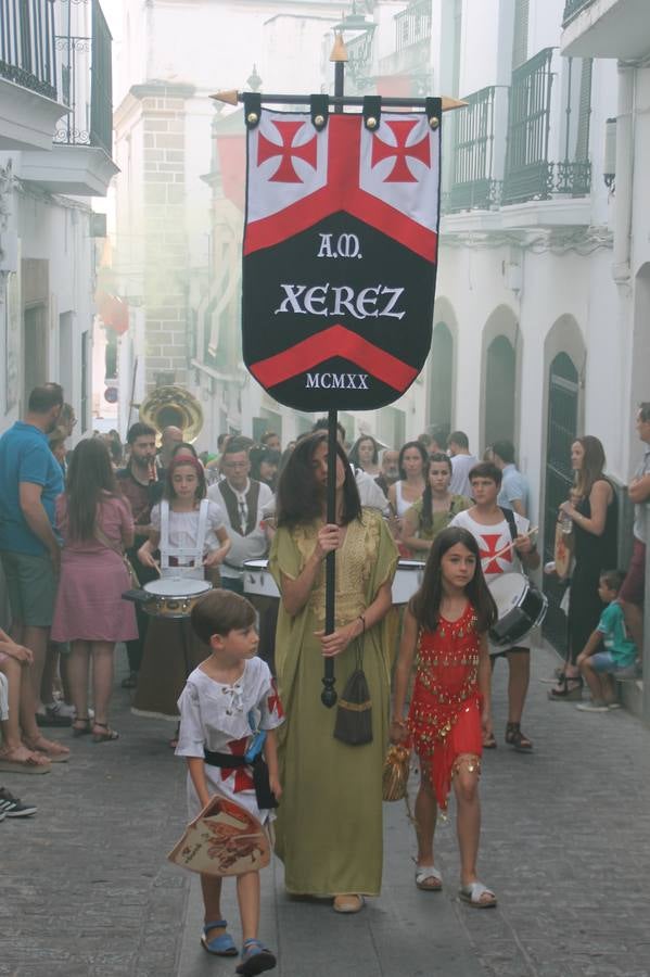 La participación popular fue nuevo protagonista del desfile teatralizado que anoche inauguró el grueso de la programación del XVI Festival Templario, invitando a propios y visitantes a revivir un pasado de leyenda, concretamente el siglo en el que La Orden del Temple marcó la vida de esta ciudad, en la que tuvo una de sus principales Encomiendas, siendo además el último reducto de Los Templarios en los reinos de España.La Asociación juvenil y cultural 'La Trouppe' estuvo al frente de la coordinación de dicho desfile que llenó de ambiente y animación las calles y plazas del centro histórico de Jerez de los Caballeros, llenas de público y engalanadas para la ocasión con pendones con la cruz templaria y otros elementos referentes a la cultura árabe que dejó su impronta en aquella época. Destacó la participación de más de 60 niñas que pusieron alegría con sus bailes a este pasacalle, junto a personajes fantásticos en zancos, la melodía de la Asociación Musical de Jerez de los Caballeros y la participación de asociaciones, como la del Belén 'Santa Ángela', Euexia Rural, además de los caballeros del campamento medieval a cargo de Cabalbur y de manera especial, la implicación de numerosos vecinos de todas las edades que desfilaron ataviados con indumentaria de la época dando vida a esta celebración.