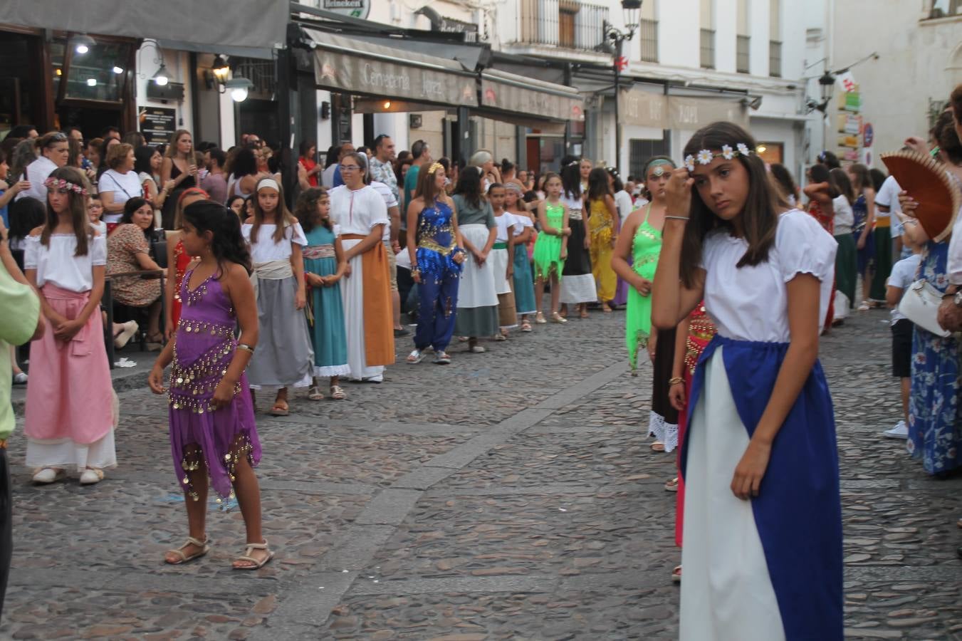 La participación popular fue nuevo protagonista del desfile teatralizado que anoche inauguró el grueso de la programación del XVI Festival Templario, invitando a propios y visitantes a revivir un pasado de leyenda, concretamente el siglo en el que La Orden del Temple marcó la vida de esta ciudad, en la que tuvo una de sus principales Encomiendas, siendo además el último reducto de Los Templarios en los reinos de España.La Asociación juvenil y cultural 'La Trouppe' estuvo al frente de la coordinación de dicho desfile que llenó de ambiente y animación las calles y plazas del centro histórico de Jerez de los Caballeros, llenas de público y engalanadas para la ocasión con pendones con la cruz templaria y otros elementos referentes a la cultura árabe que dejó su impronta en aquella época. Destacó la participación de más de 60 niñas que pusieron alegría con sus bailes a este pasacalle, junto a personajes fantásticos en zancos, la melodía de la Asociación Musical de Jerez de los Caballeros y la participación de asociaciones, como la del Belén 'Santa Ángela', Euexia Rural, además de los caballeros del campamento medieval a cargo de Cabalbur y de manera especial, la implicación de numerosos vecinos de todas las edades que desfilaron ataviados con indumentaria de la época dando vida a esta celebración.