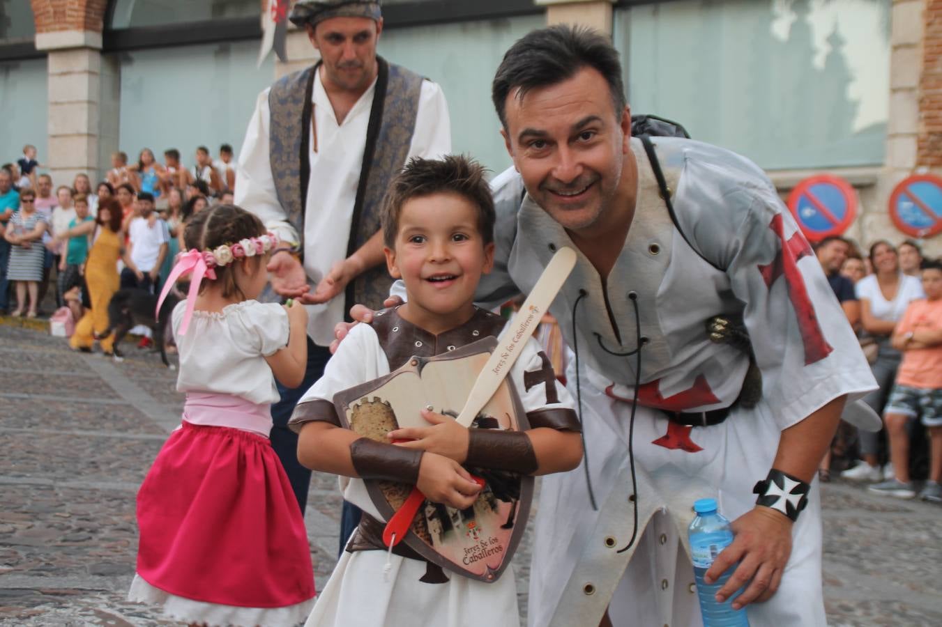 La participación popular fue nuevo protagonista del desfile teatralizado que anoche inauguró el grueso de la programación del XVI Festival Templario, invitando a propios y visitantes a revivir un pasado de leyenda, concretamente el siglo en el que La Orden del Temple marcó la vida de esta ciudad, en la que tuvo una de sus principales Encomiendas, siendo además el último reducto de Los Templarios en los reinos de España.La Asociación juvenil y cultural 'La Trouppe' estuvo al frente de la coordinación de dicho desfile que llenó de ambiente y animación las calles y plazas del centro histórico de Jerez de los Caballeros, llenas de público y engalanadas para la ocasión con pendones con la cruz templaria y otros elementos referentes a la cultura árabe que dejó su impronta en aquella época. Destacó la participación de más de 60 niñas que pusieron alegría con sus bailes a este pasacalle, junto a personajes fantásticos en zancos, la melodía de la Asociación Musical de Jerez de los Caballeros y la participación de asociaciones, como la del Belén 'Santa Ángela', Euexia Rural, además de los caballeros del campamento medieval a cargo de Cabalbur y de manera especial, la implicación de numerosos vecinos de todas las edades que desfilaron ataviados con indumentaria de la época dando vida a esta celebración.