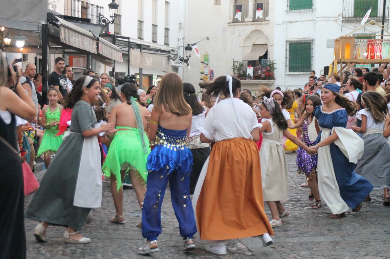 La participación popular fue nuevo protagonista del desfile teatralizado que anoche inauguró el grueso de la programación del XVI Festival Templario, invitando a propios y visitantes a revivir un pasado de leyenda, concretamente el siglo en el que La Orden del Temple marcó la vida de esta ciudad, en la que tuvo una de sus principales Encomiendas, siendo además el último reducto de Los Templarios en los reinos de España.La Asociación juvenil y cultural 'La Trouppe' estuvo al frente de la coordinación de dicho desfile que llenó de ambiente y animación las calles y plazas del centro histórico de Jerez de los Caballeros, llenas de público y engalanadas para la ocasión con pendones con la cruz templaria y otros elementos referentes a la cultura árabe que dejó su impronta en aquella época. Destacó la participación de más de 60 niñas que pusieron alegría con sus bailes a este pasacalle, junto a personajes fantásticos en zancos, la melodía de la Asociación Musical de Jerez de los Caballeros y la participación de asociaciones, como la del Belén 'Santa Ángela', Euexia Rural, además de los caballeros del campamento medieval a cargo de Cabalbur y de manera especial, la implicación de numerosos vecinos de todas las edades que desfilaron ataviados con indumentaria de la época dando vida a esta celebración.