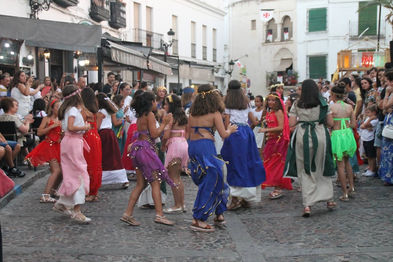 La participación popular fue nuevo protagonista del desfile teatralizado que anoche inauguró el grueso de la programación del XVI Festival Templario, invitando a propios y visitantes a revivir un pasado de leyenda, concretamente el siglo en el que La Orden del Temple marcó la vida de esta ciudad, en la que tuvo una de sus principales Encomiendas, siendo además el último reducto de Los Templarios en los reinos de España.La Asociación juvenil y cultural 'La Trouppe' estuvo al frente de la coordinación de dicho desfile que llenó de ambiente y animación las calles y plazas del centro histórico de Jerez de los Caballeros, llenas de público y engalanadas para la ocasión con pendones con la cruz templaria y otros elementos referentes a la cultura árabe que dejó su impronta en aquella época. Destacó la participación de más de 60 niñas que pusieron alegría con sus bailes a este pasacalle, junto a personajes fantásticos en zancos, la melodía de la Asociación Musical de Jerez de los Caballeros y la participación de asociaciones, como la del Belén 'Santa Ángela', Euexia Rural, además de los caballeros del campamento medieval a cargo de Cabalbur y de manera especial, la implicación de numerosos vecinos de todas las edades que desfilaron ataviados con indumentaria de la época dando vida a esta celebración.