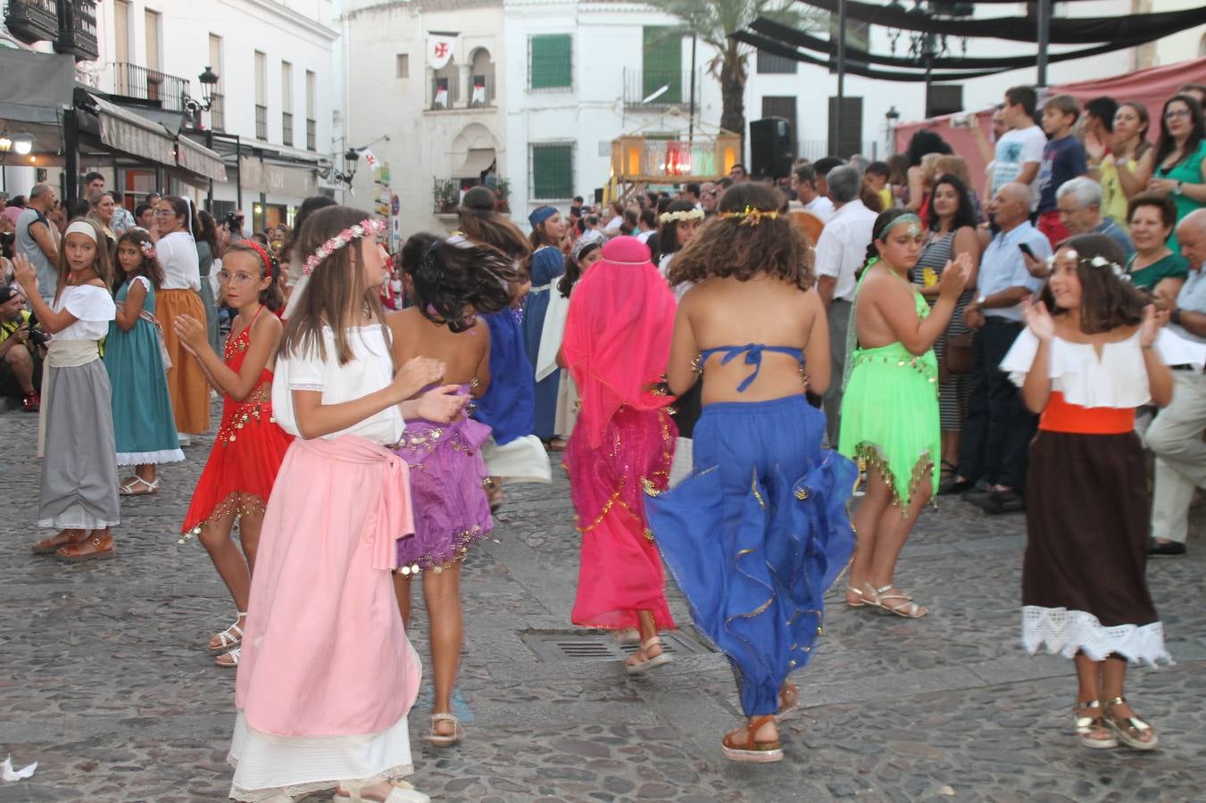 La participación popular fue nuevo protagonista del desfile teatralizado que anoche inauguró el grueso de la programación del XVI Festival Templario, invitando a propios y visitantes a revivir un pasado de leyenda, concretamente el siglo en el que La Orden del Temple marcó la vida de esta ciudad, en la que tuvo una de sus principales Encomiendas, siendo además el último reducto de Los Templarios en los reinos de España.La Asociación juvenil y cultural 'La Trouppe' estuvo al frente de la coordinación de dicho desfile que llenó de ambiente y animación las calles y plazas del centro histórico de Jerez de los Caballeros, llenas de público y engalanadas para la ocasión con pendones con la cruz templaria y otros elementos referentes a la cultura árabe que dejó su impronta en aquella época. Destacó la participación de más de 60 niñas que pusieron alegría con sus bailes a este pasacalle, junto a personajes fantásticos en zancos, la melodía de la Asociación Musical de Jerez de los Caballeros y la participación de asociaciones, como la del Belén 'Santa Ángela', Euexia Rural, además de los caballeros del campamento medieval a cargo de Cabalbur y de manera especial, la implicación de numerosos vecinos de todas las edades que desfilaron ataviados con indumentaria de la época dando vida a esta celebración.