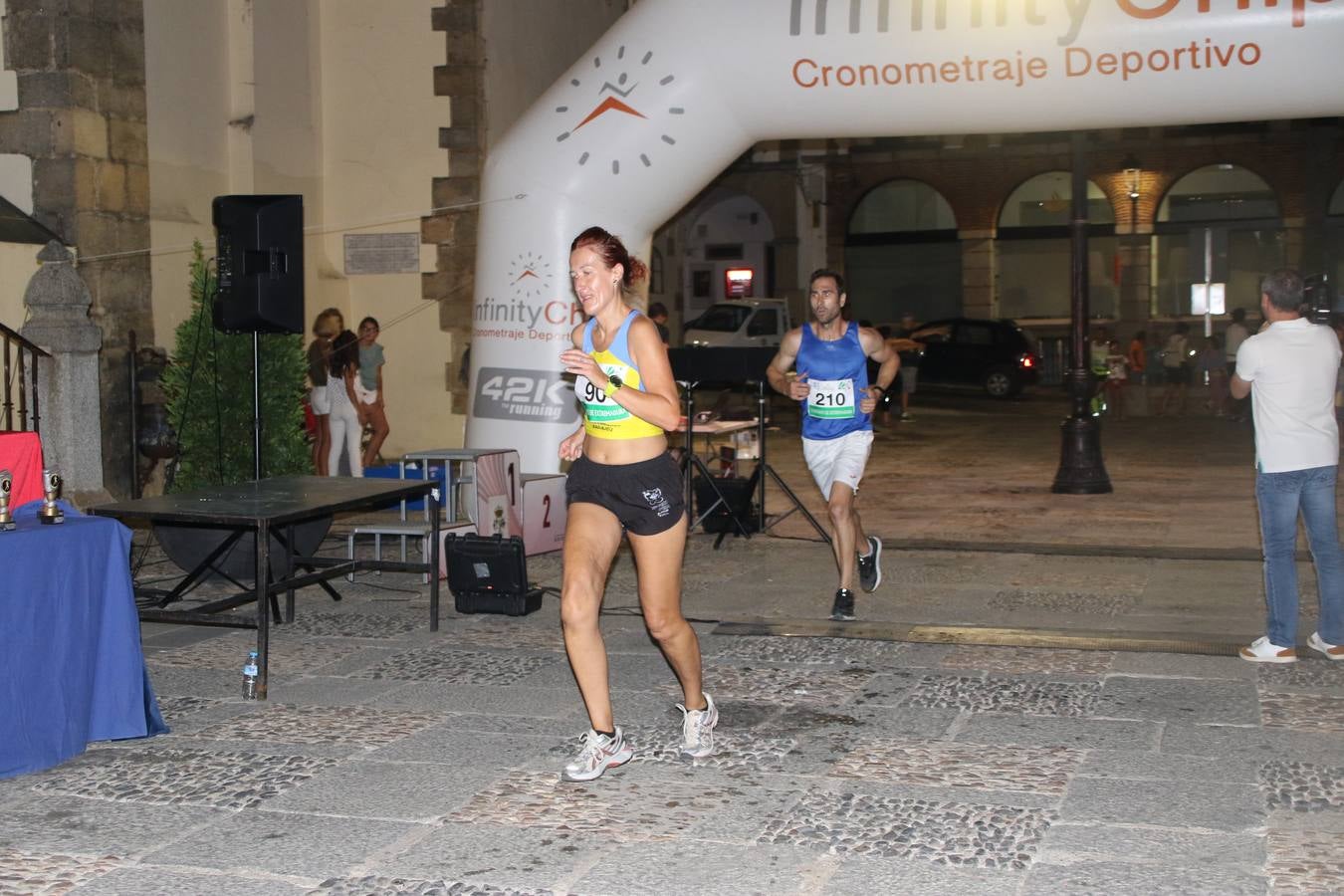 La Plaza de España de Jerez de los Caballeros acogió, ayer, la V Carrera Popular Nocturna 'Recorriendo el Medievo', organizada por el Ayuntamiento del municipio con la colaboración del Plan de Dinamización Deportiva de la Mancomunidad Sierra Suroeste. Las principales calles del municipio volvieron a convertirse en el mejor escenario para el desarrollo de esta prueba deportiva que, año tras año, se consolida como una de las citas más destacadas del calendario estival jerezano y en la que la solidaridad, también, está muy presente. Así, se lograron recaudar 153 kilos y 22 euros que irán destinados al almacén de alimentos que gestiona la Asamblea local de Cruz Roja en el municipio.En esta edición, han participado unos 200 corredores de la localidad y alrededores, siendo Manuel Gómez Lucas y Tina María Ramos, vencedores de la clasificación general.