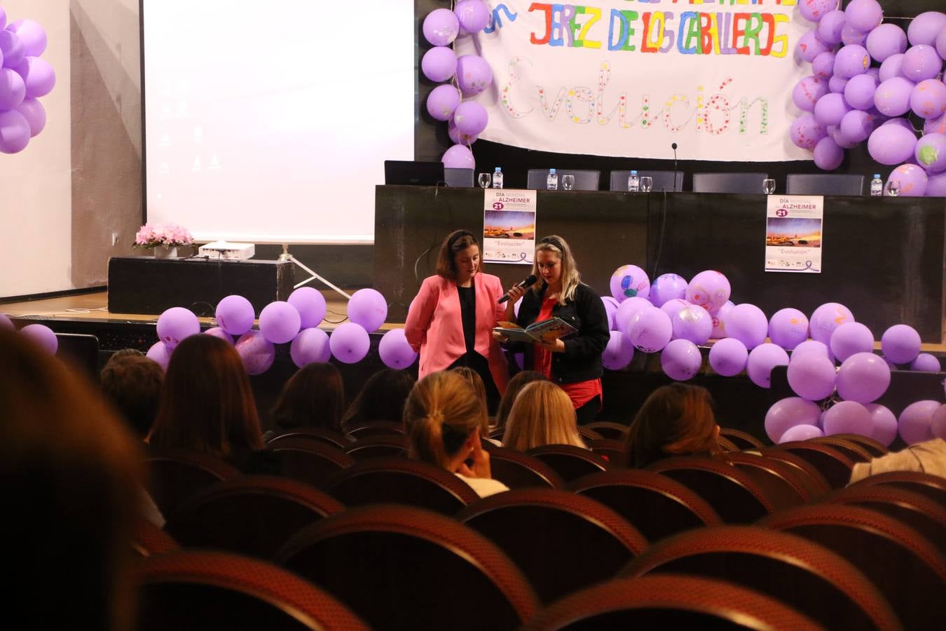 Ante las condiciones climatológicas adversas, el auditorio del Conventual San Agustín se convirtió en el mejor escenario para acoger las actividades que, con motivo del Día Mundial del Alzhéimer, la Asociación de Familiares de Personas con Alzheimer y otras Demencias de Jerez de los Caballeros y Comarca Sierra Suroeste (AFAD) había preparado en el municipio. Una gran pancarta con el lema 'Evolución', realizada por los alumnos del Colegio de Educación Especial 'Nuestra Señora de Aguasantas', presidió el escenario, y una marea de globos morados con distintos dibujos, realizados por los alumnos de los colegios 'Sotomayor y Terrazas' y 'El Rodeo', tiñó de color, empatía, sensibilidad y creatividad el citado auditorio.La jornada comenzó con la canción 'Estoy contigo' de la Oreja de Van Gogh. A continuación, tuvo lugar una mesa redonda en la que cinco personas contaron su testimonio en relación a esta enfermedad. Posteriormente, se dio paso a la lectura de un manifiesto; la entrega de diploma a las personas y colectivos colaboradores, y la lectura de dos cuentos infantiles.