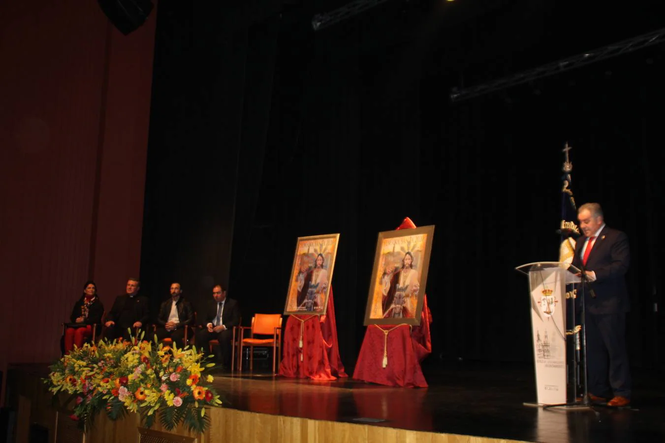 La autora del cartel,Nuria Barrera, el presidente de la Junta de Cofradías, el alcalde de Jerez, el Hermano Mayor de la Cofradía de Santo Domingo de Guzmán y el párroco de la ciudad, junto al cartel que anuncia la Semana Santa de Jerez de los Caballeros 2020. 