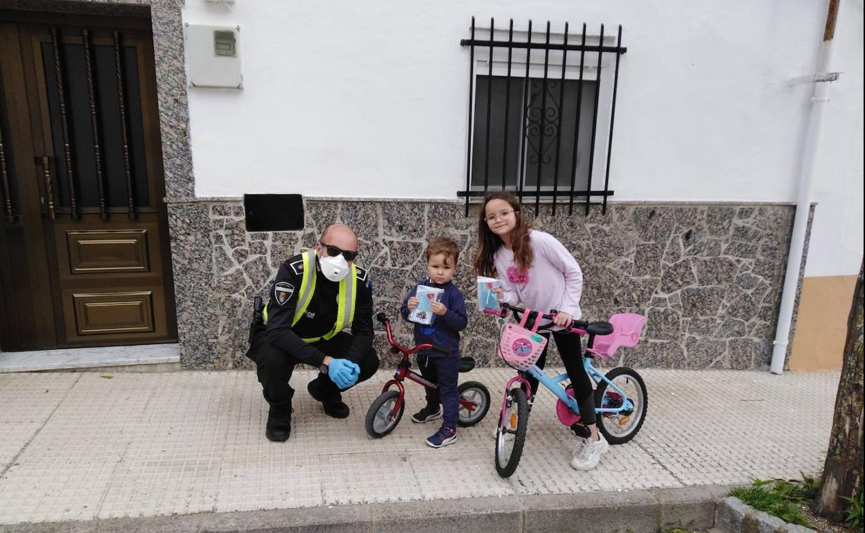 La Policía Local haciendo entrega de mascarillas a dos menores. 