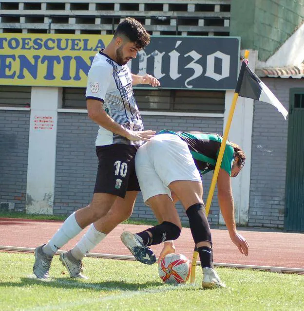 Mamobe y Rafa pelean por un balón junto al córner. 