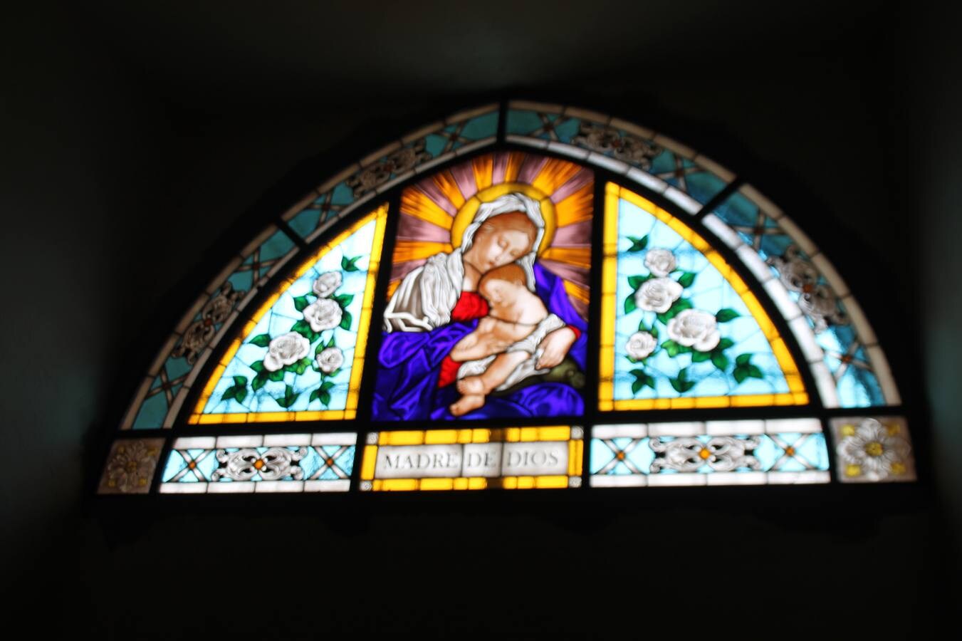 Vidriera con motivo iconoclasta de la Virgen Madre de Dios, colocada en la ventana en forma de arco que comunica con la Corredera Hernando de Soto.