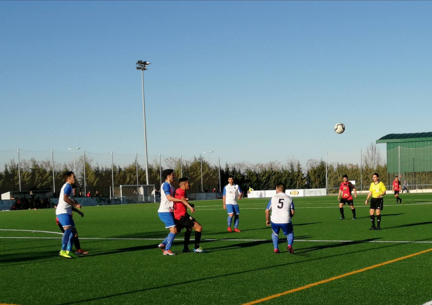Varios jugadores locales presionan a un delantero rival