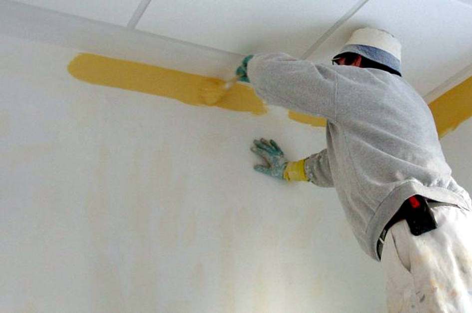 Un pintor trabaja en el interior de una viciend