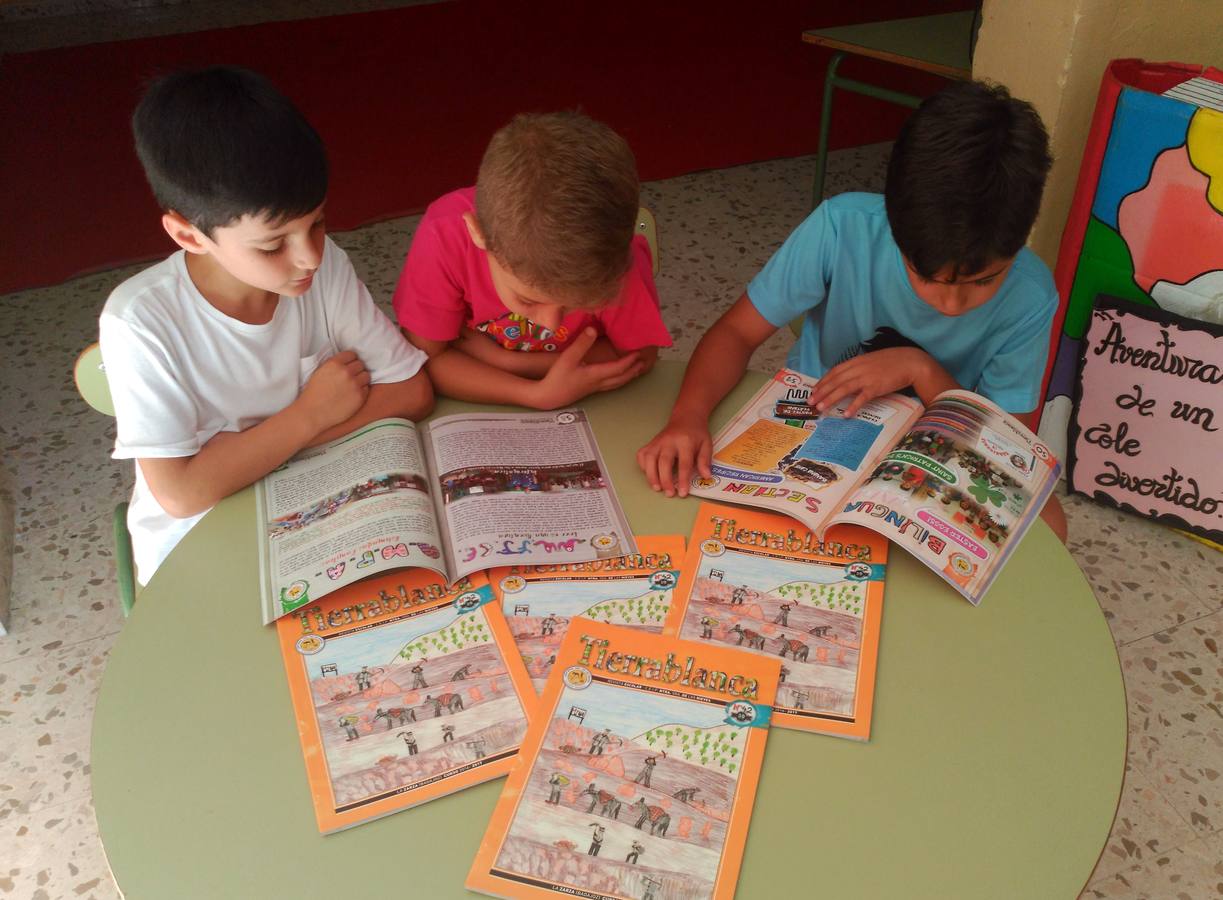 Unos escolares leen la revista