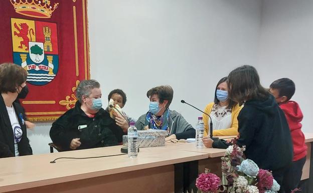 Los nietos de Valentina del Barco le entregan varios regalos en su acto de homenaje.