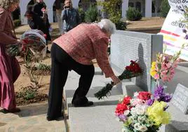 Mari Castilla, nieta de una fusilada, coloca unas rosas en el memorial del Cementerio de Llerena.