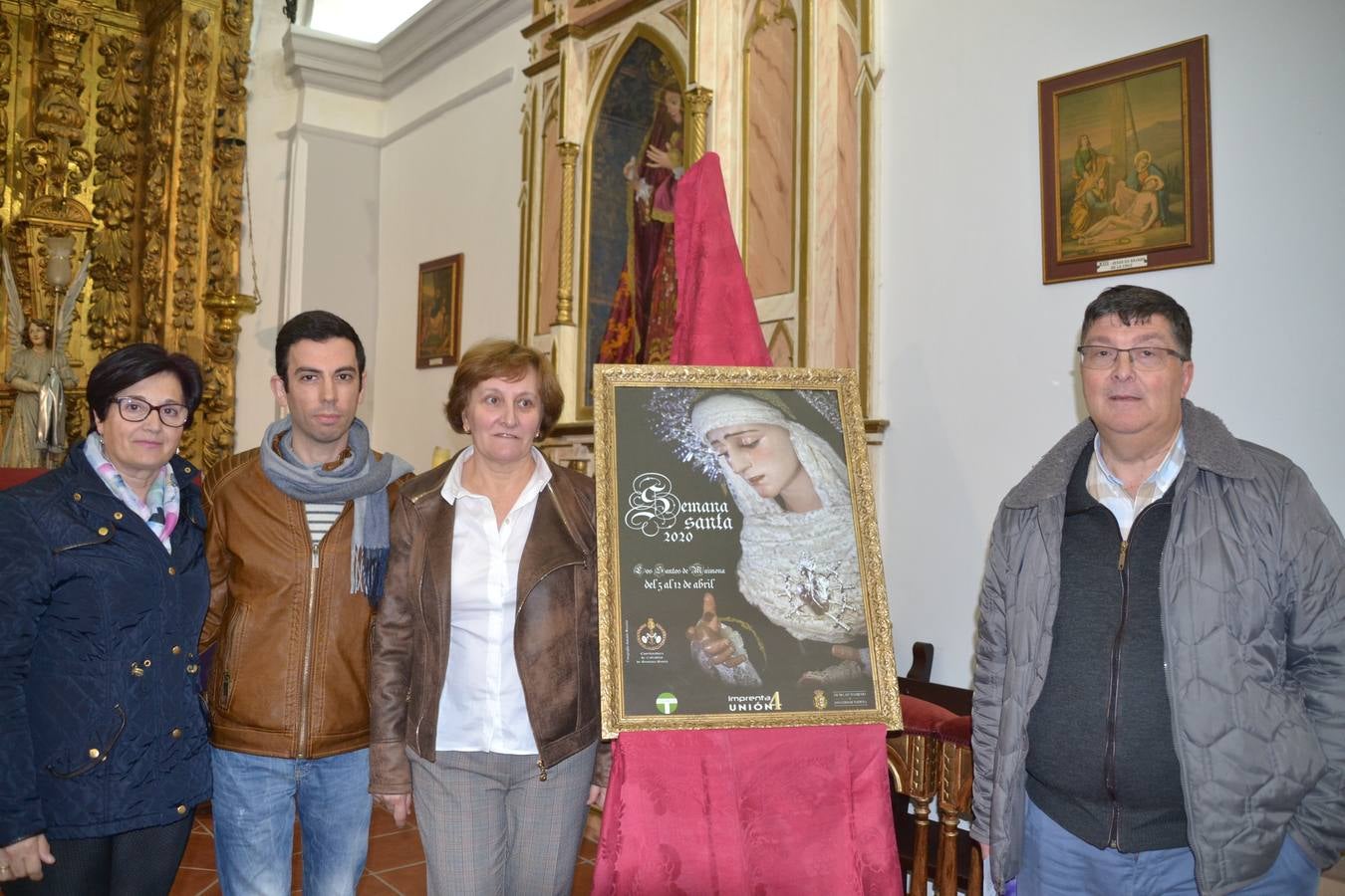 El autor del cartel con el párroco, la presidenta de la Coordinadora de Cofradías y la representante de la Hermandad de la Virgen de los Dolores 