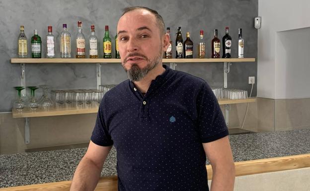 Juan antonio Gómez muestra la estantería que ha fabricado para el bar 