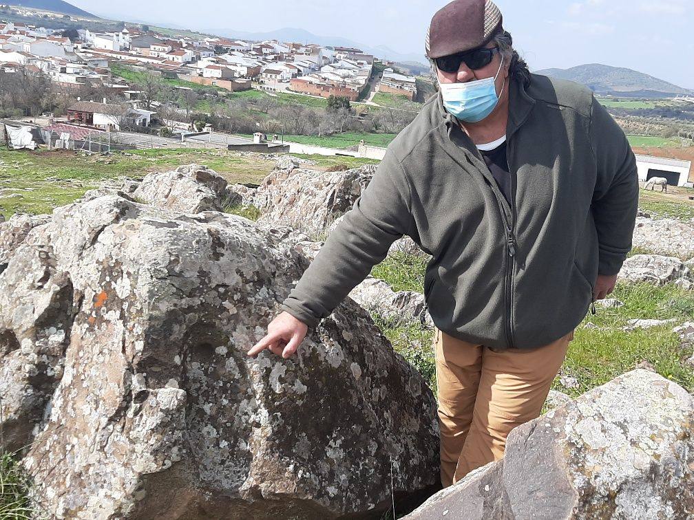 Lorenzo Gallardo enseña una de las cazoletas en el peñón de rocas cercano al pueblo 