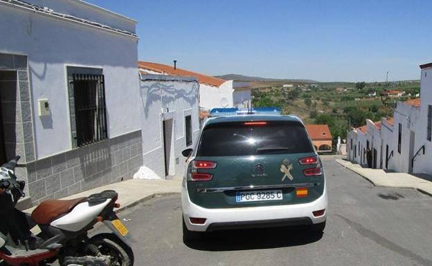 La guardia civil vigila a cierta distancia de la casa donde se ve al hombre con la horquilla en las manos 
