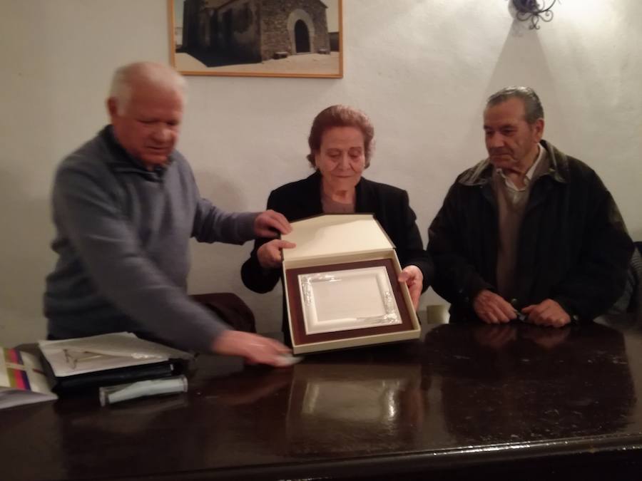 El secretario Julián Liberal y el vicepresidente Plácido Morán hacen entrega a Catalina Lancho de la placa que la reconoce como Hermana de Honor de la Cofradía del Nazareno. 