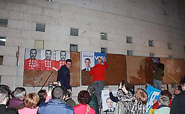 Representantes de los distintos partidos pegan los carteles 