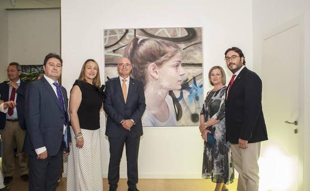 Los hermanos Vicente, Reyes, Eugenio, Laura y Miguel Manzano Otero delante de la obra ganadora del X certamen de pintura Laura Otero. 