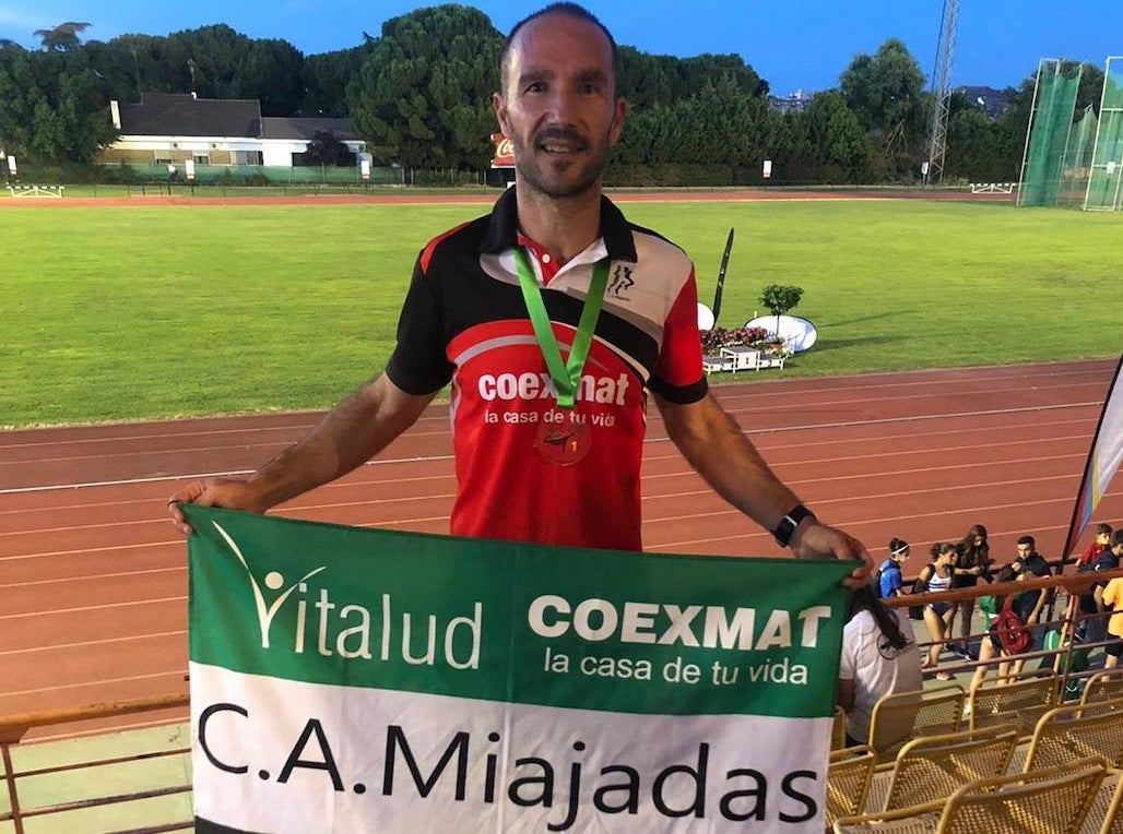 Sergio Redondo posa con la bandera del Club Atletismo Miajadas 