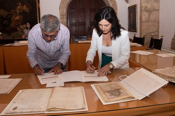 El alcalde, Antonio Díaz, firma la recepción de los documentos restaurados.