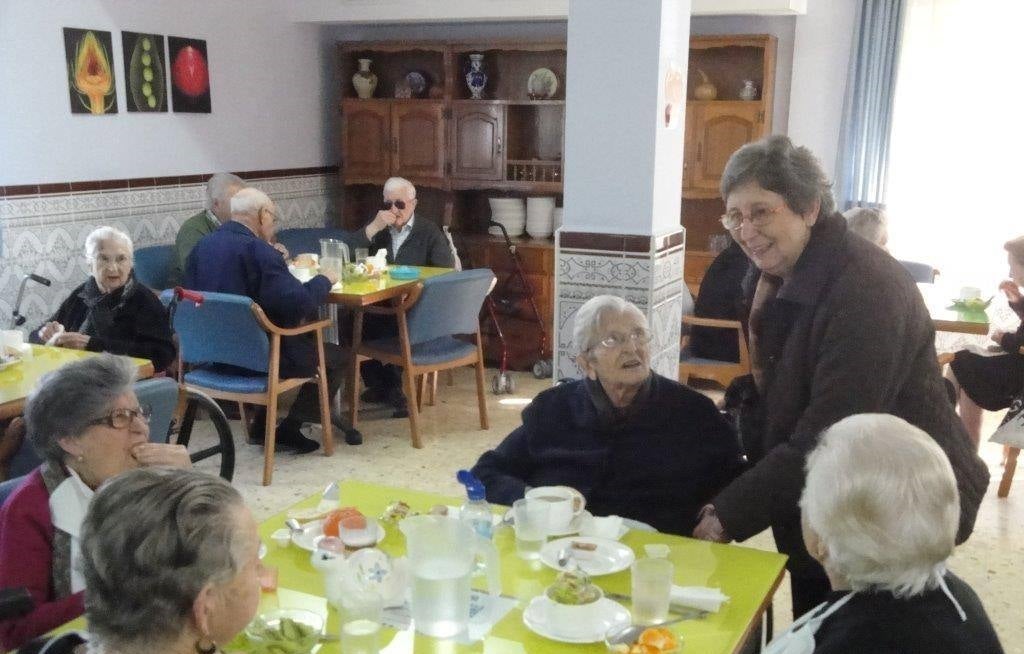 Las carmelitas visitando a los ancianos mientras desayunan. 