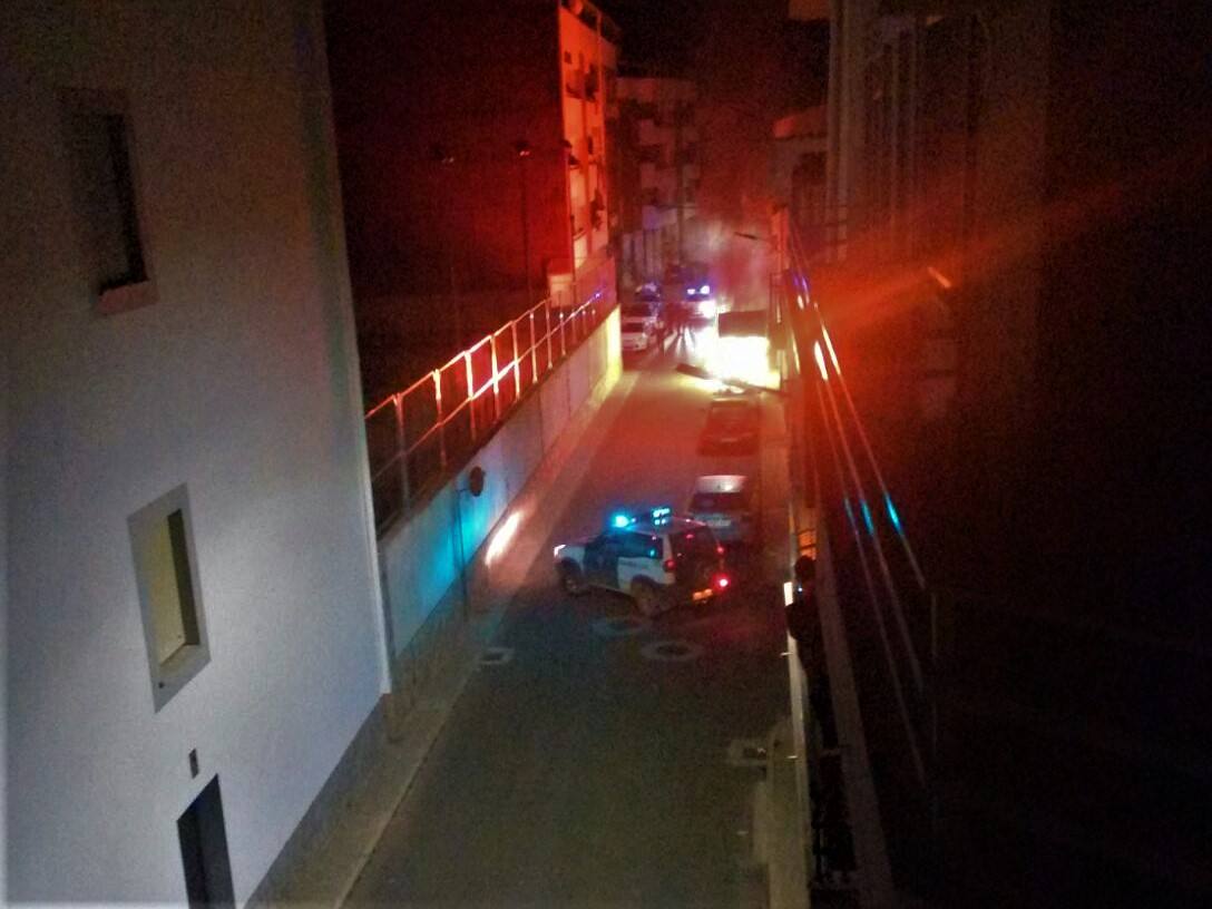 Calle Donoso Cortés acordonada con el coche ardiendo al fondo. 