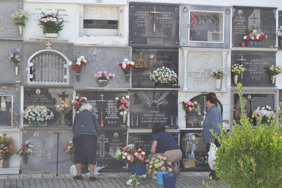 Mujeres colocando flores en el cementerio. 