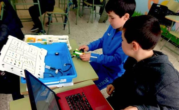 Dos alumnos del colegio construyendo su propio robot durante un taller celebrado en Monesterio 