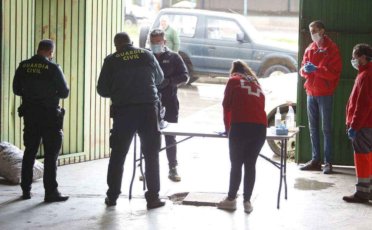 Voluntarios de Cruz Roja junto a agentes de la Guardia Civil, durante el reparto de mascarillas 