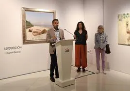 Ricardo Cabezas durante la presentación de la exposición con el óleo de Eduardo Naranjo de fondo