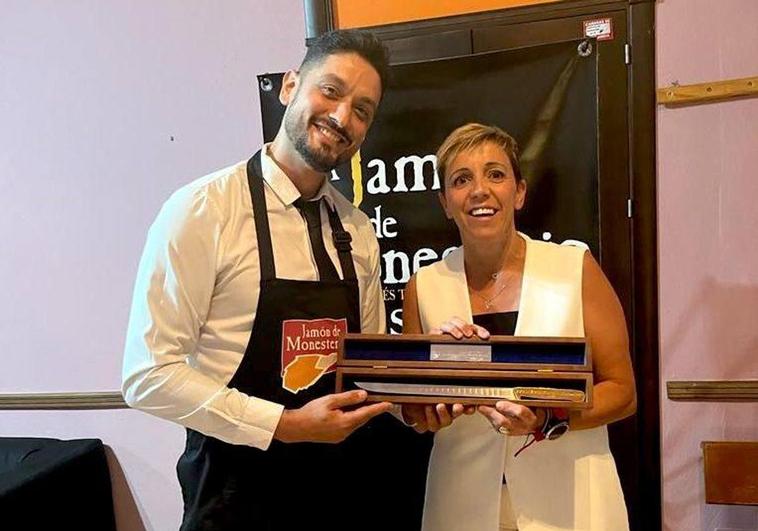 Javier Torres recibe de manos de la alcaldesa de Monesterio, Loli Vargas, el Cuchillo Jamonero de Oro 2023