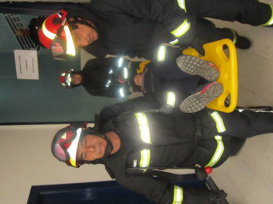 Bomberos sacando al herido en camilla