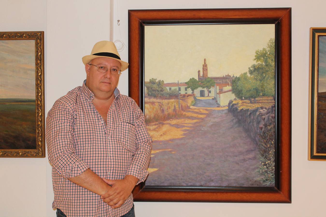 El hijo del pintor junto a una de las obras de su padre.