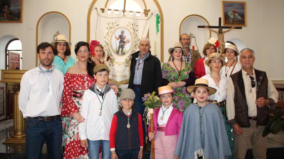 Foto de familia de romeros y romeras, junto a directivos de la Hermandad y el nuevo estandarte 