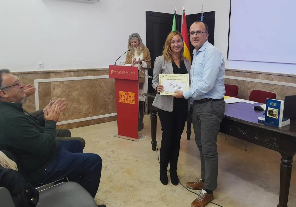El alcalde entrega el premio a la ganadora de los Coloquios