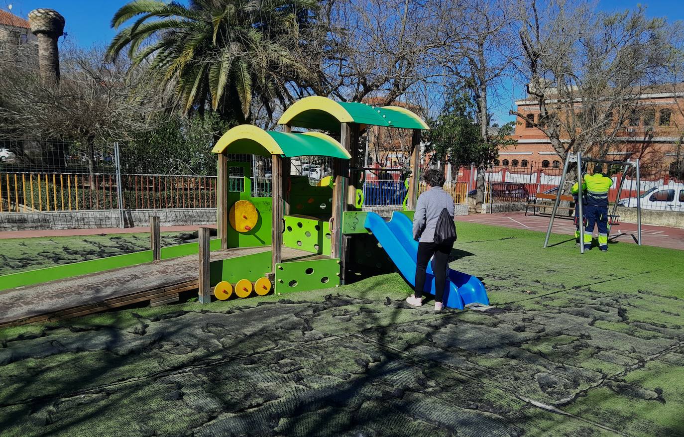 Una abuela en el parque con operarios municipales desmontando el columpio