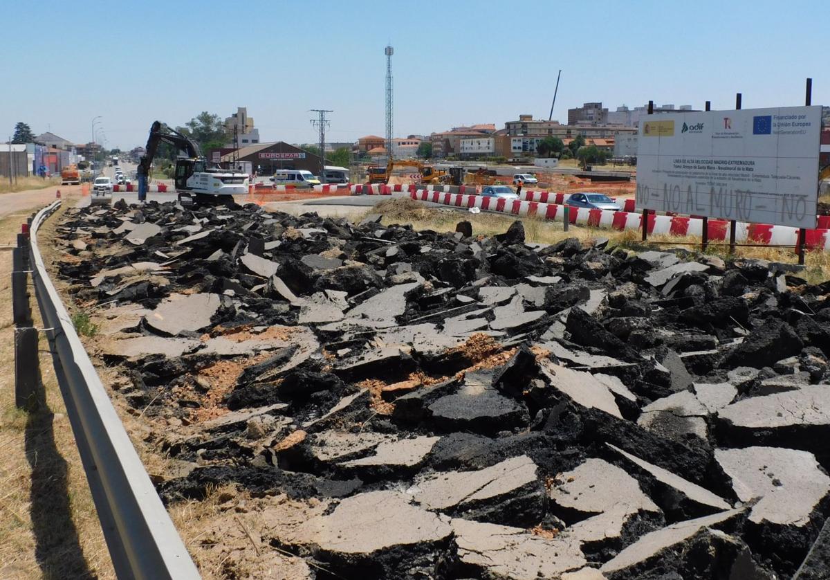 Actuaciones en marcha frente al cartel que anuncia las obras del tren