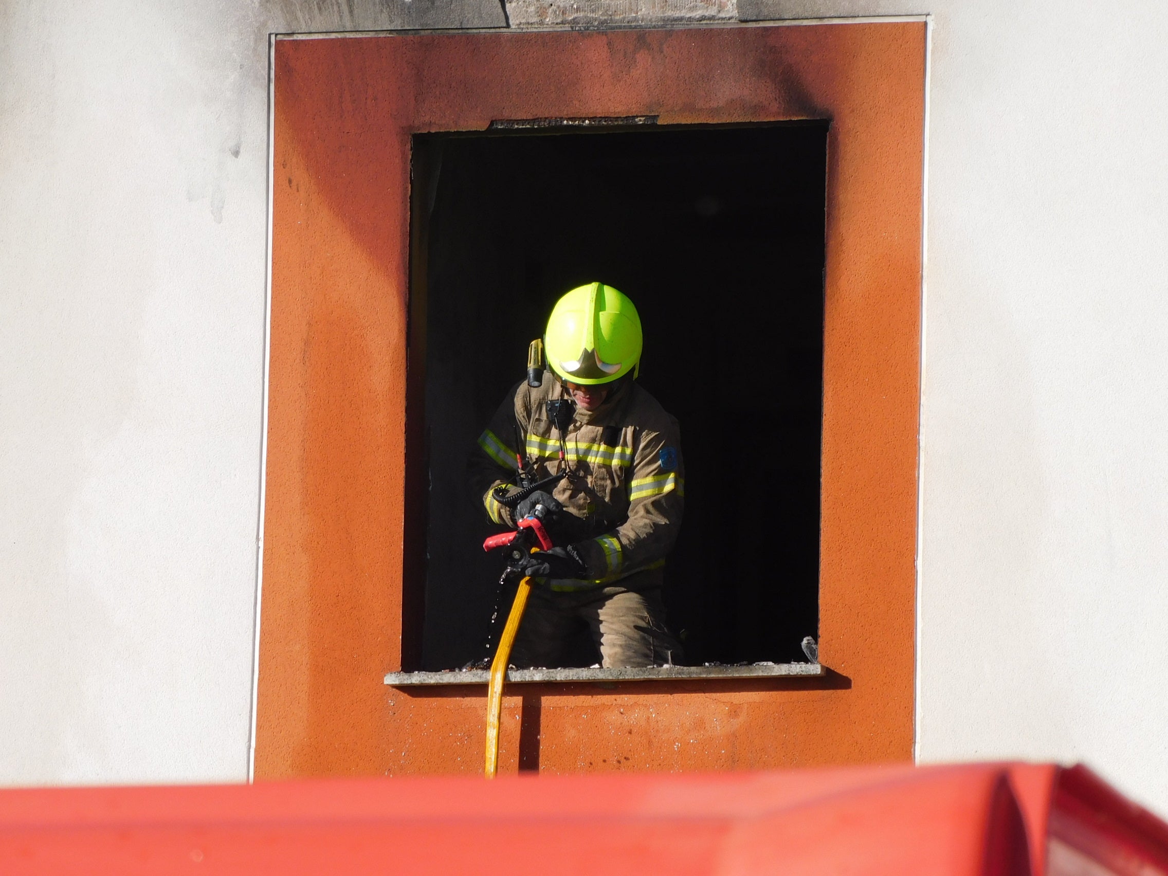 Bombero en la ventana de la vivienda siniestrada