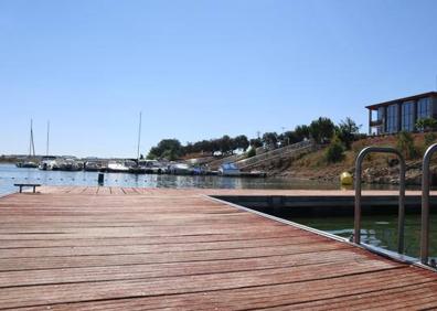 Imagen secundaria 1 - Arriba, césped para esparcimiento, donde ambién hay merenderos. Abajo, a la izquierda, pantalán dedicado al baño; enfrente, el puerto deportivo y en lo alto, el restaurante panorámico. Abajo, a la derecha, zona de baño con escalerillas. 
