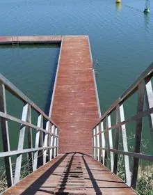 Imagen secundaria 2 - Arriba, césped para esparcimiento, donde ambién hay merenderos. Abajo, a la izquierda, pantalán dedicado al baño; enfrente, el puerto deportivo y en lo alto, el restaurante panorámico. Abajo, a la derecha, zona de baño con escalerillas. 