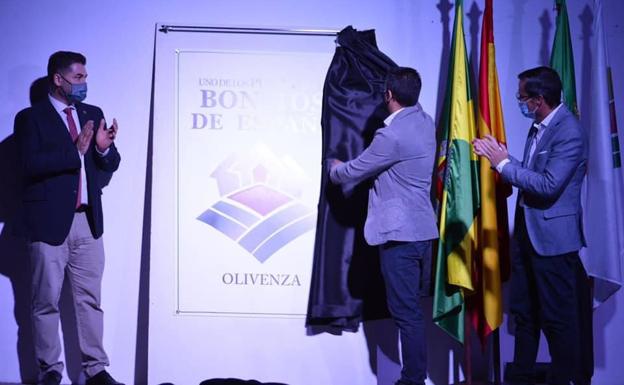 Imagen principal - Arriba, momento en que las autoridades descubren el cartel de la proclamación. Abajo, momentos de las intervenciones del presidente de la Junta de Extremadura y el alcalde de Olivenza. 