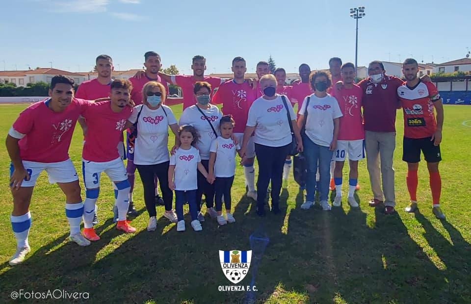 Las componentes de Sonríe Olivenza, junto a la plantilla del Olivenza FC, tras el saque de honor en el partido disputado en casa el pasado 10 de octubre. 