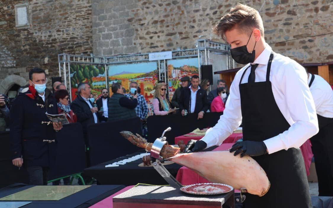 Imagen secundaria 2 - Arriba, momento de la cata de vinos de denominación de origen Ribera del Guadiana. Abajo, concurso de corte de jamón, con el ganador Daniel Acedo en acción. 