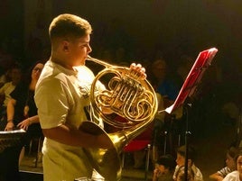 El músico toca la trompa.