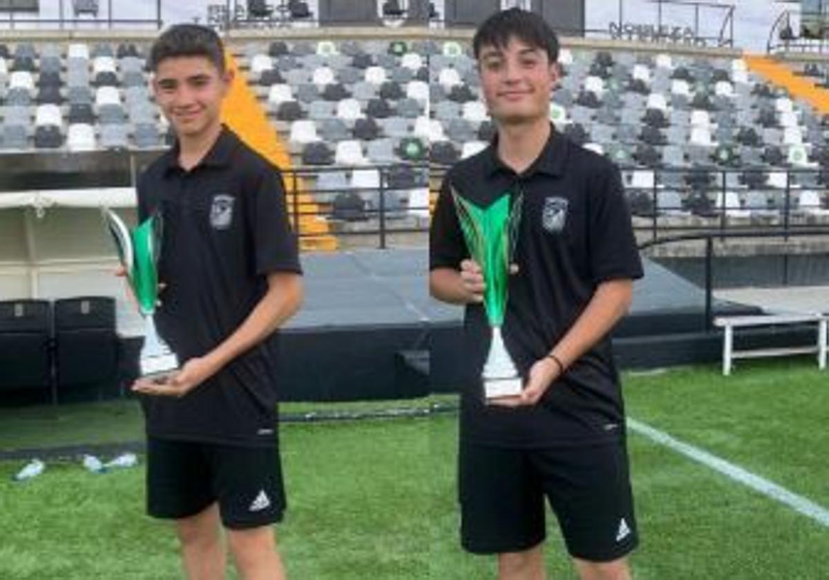 Ambos jugadores posan orgullosos con el trofeo.