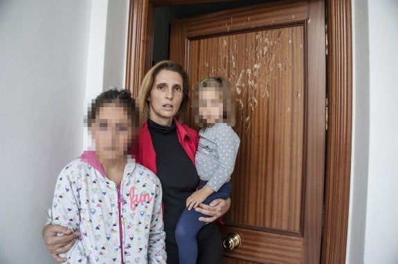 Pilar Díaz, a la puerta de su casa, con sus hijas Sofía y Ana.