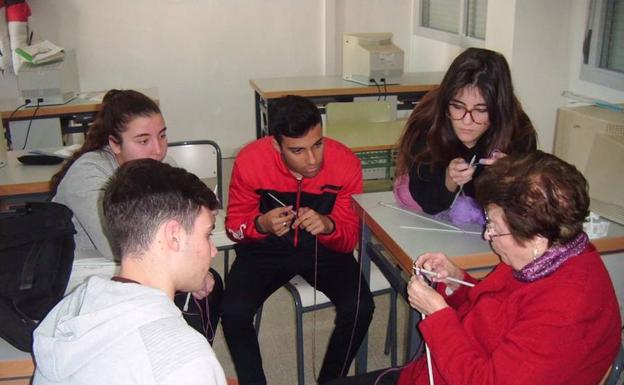 Alumnos y alumnas del IES Diez-Canedo aprendiendo a tejer con una experta.