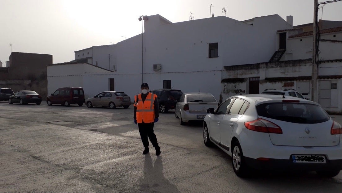 Una oluntaria de Protección Civil indica a los coches la entrada en la carpa 